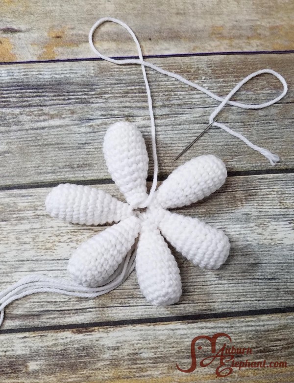 Six crocheted white daisy petals formed together in a circle.